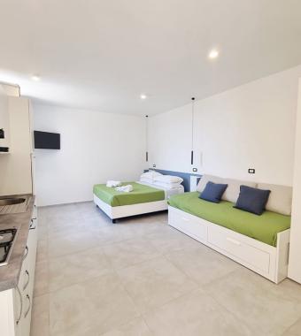 Moderno monolocale luminoso, con cucina attrezzata e letti confortevoli, accogliente e minimalista.