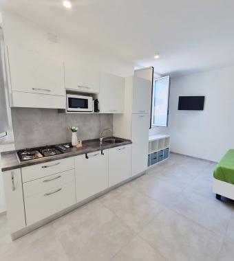 Cucina moderna, luminosa e minimalista con dettagli eleganti e funzionali, atmosfera accogliente.