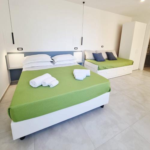 Camera moderna, luminosa, letto matrimoniale verde, accogliente, atmosfera rilassante, minimalista, ordinata.